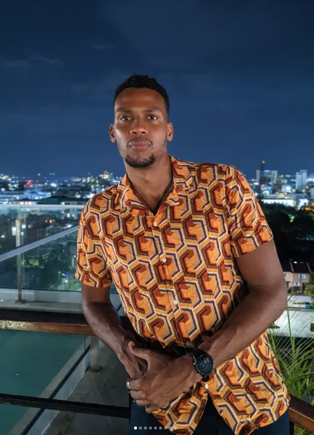 Kyle Hector standing on a balcony at night.